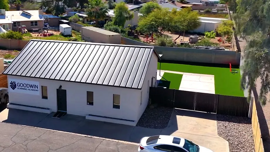 An aerial view of the Goodwin Learning Academy campus at 1307 E. Southern Ave, Mesa, AZ 85204, showing the building, the fenced play yard and the parking area