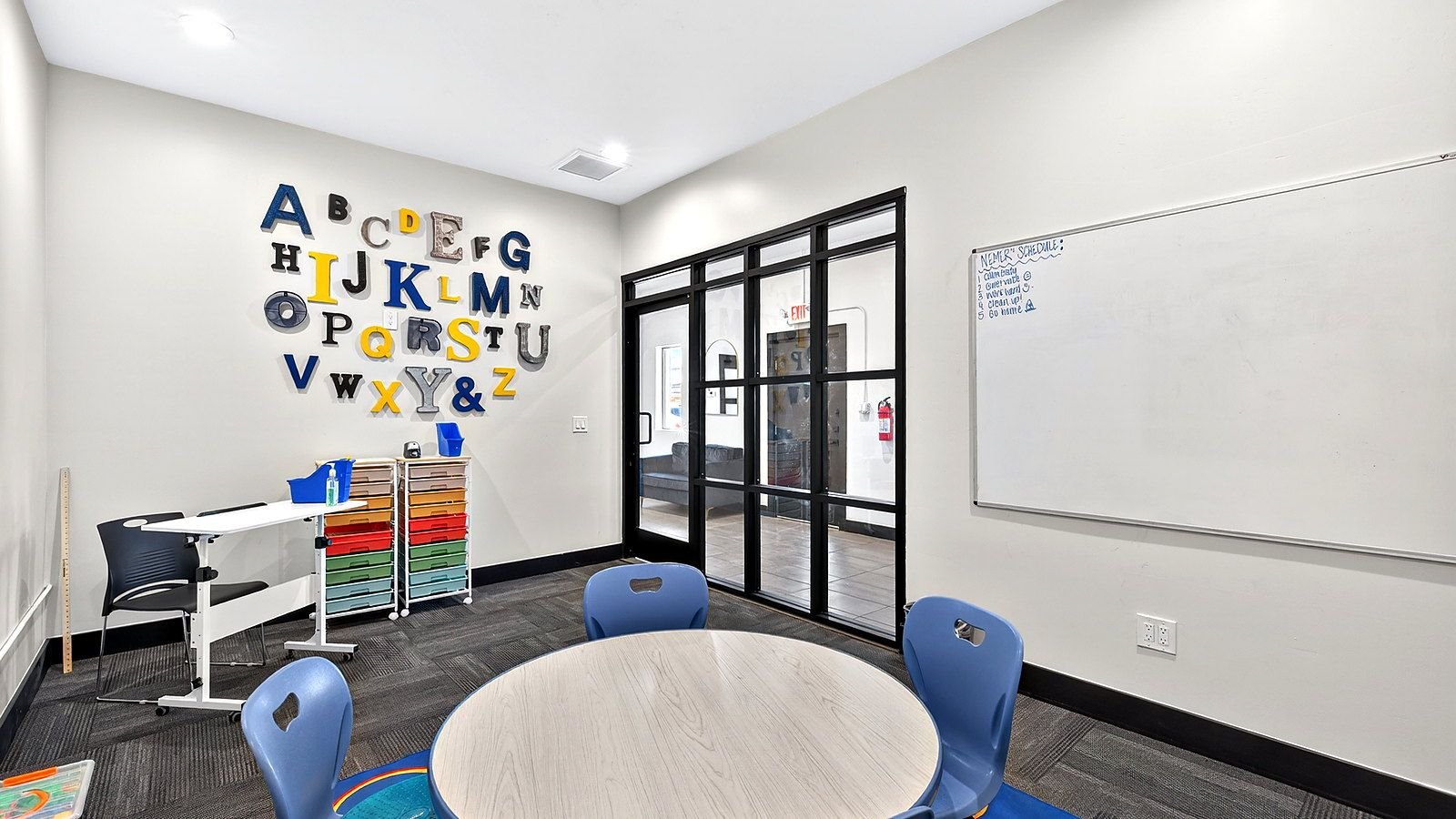 A Goodwin Learning Academy early-elementary classroom with an alphabet wall, a round work table and small-group seating