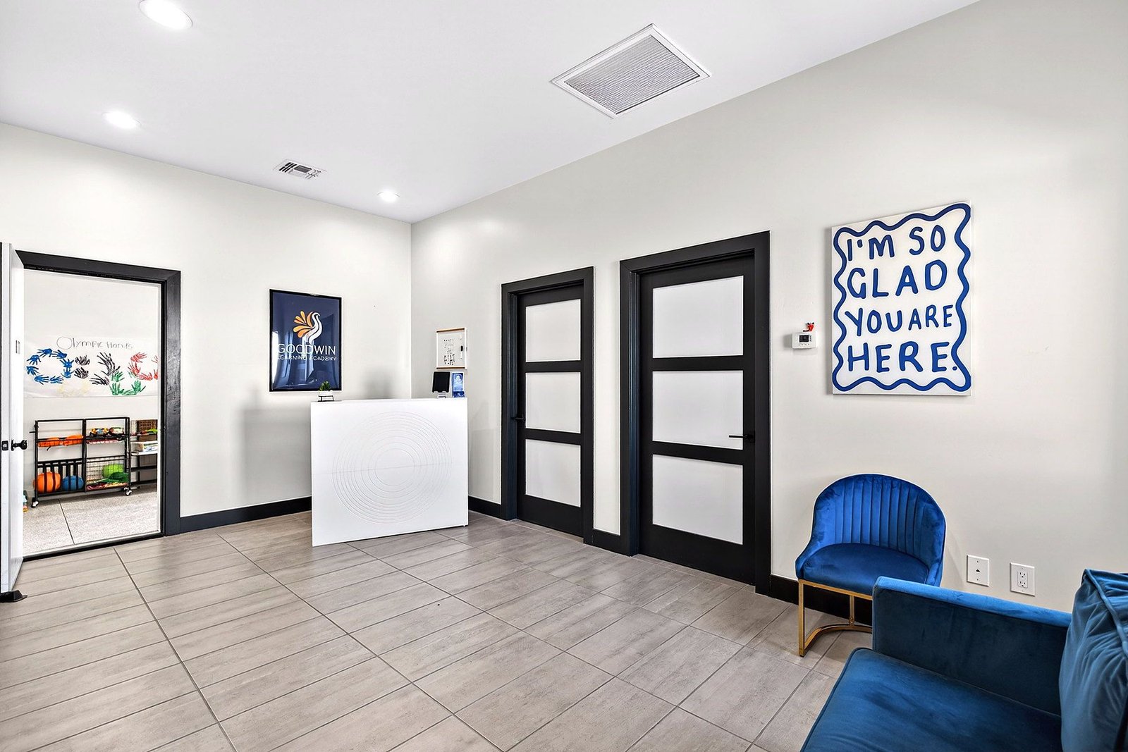 The reception area at Goodwin Learning Academy, with a hand-lettered sign reading I'm so glad you are here