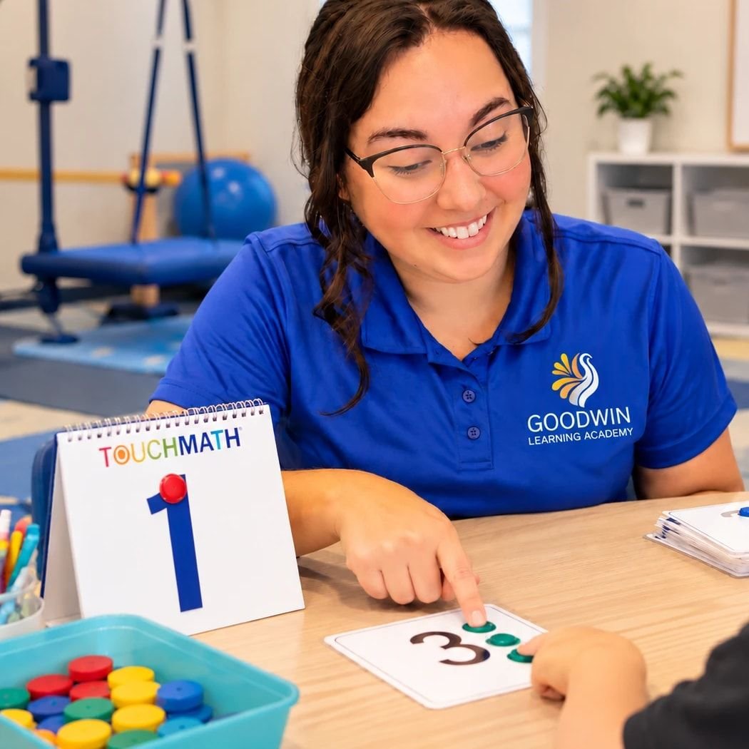 Haley Jensen, Partnership Programs Director, pointing to the dots on a TouchMath number card as a student touches them